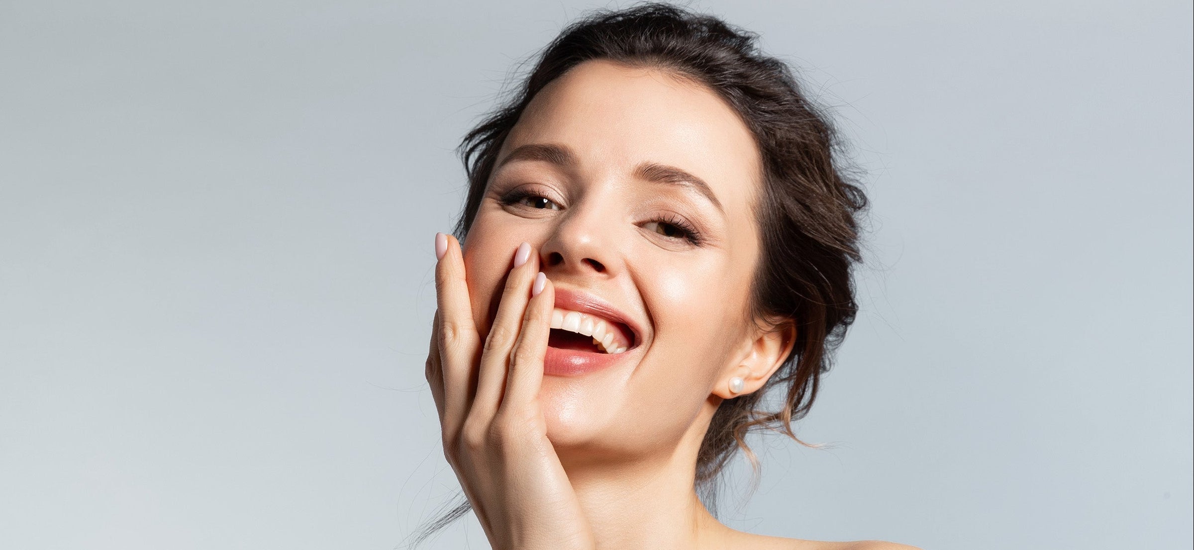 Woman with a bright smile against a plain background
